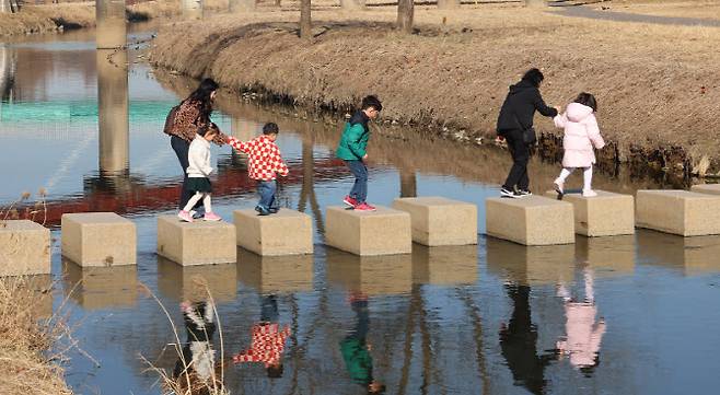 포근한 봄 날씨를 보인 25일 인천 연수구 승기천에서 어린이들이 징검다리를 건너고 있다. (사진=연합뉴스)