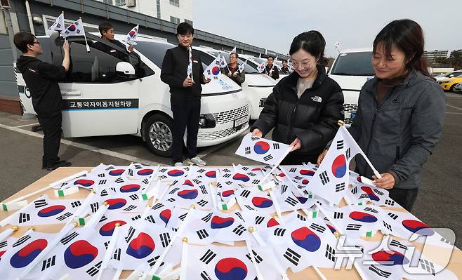 제107주년 3·1절을 사흘 앞둔 26일 경기 수원시 권선구 수원시교통약자지원센터 한아름콜에서 직원들이 3·1절을 맞아 교통약자지원차량에 부착할 태극기를 준비하고 있다. 2026.2.26 ⓒ 뉴스1 김영운 기자