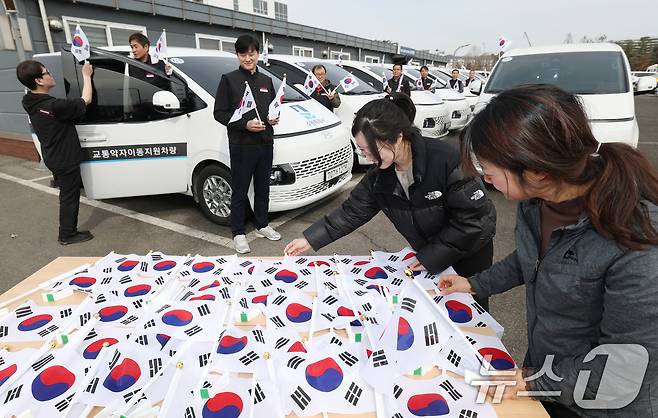 제107주년 3·1절을 사흘 앞둔 26일 경기 수원시 권선구 수원시교통약자지원센터 한아름콜에서 직원들이 3·1절을 맞아 교통약자지원차량에 부착할 태극기를 준비하고 있다. 2026.2.26 ⓒ 뉴스1 김영운 기자