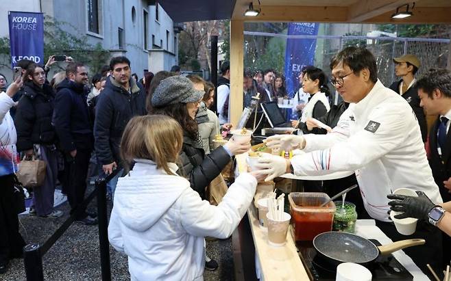 최휘영 문화체육관광부 장관(오른쪽)이 이탈리아 밀라노 코리아하우스에서 길거리음식을 판매하고 있다. 문화체육관광부