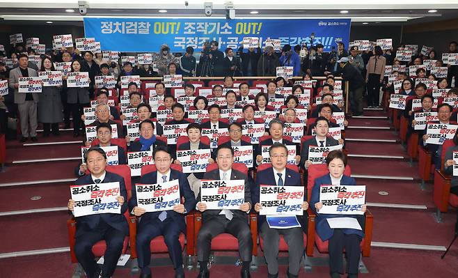 이재명 대통령 사건 공소 취소와 국정조사 추진을 위한 의원모임에 참여한 더불어민주당 의원들이 23일 서울 여의도 국회 의원회관에서 열린 출범식 및 결의대회에서 손팻말을 들고 있다./연합뉴스