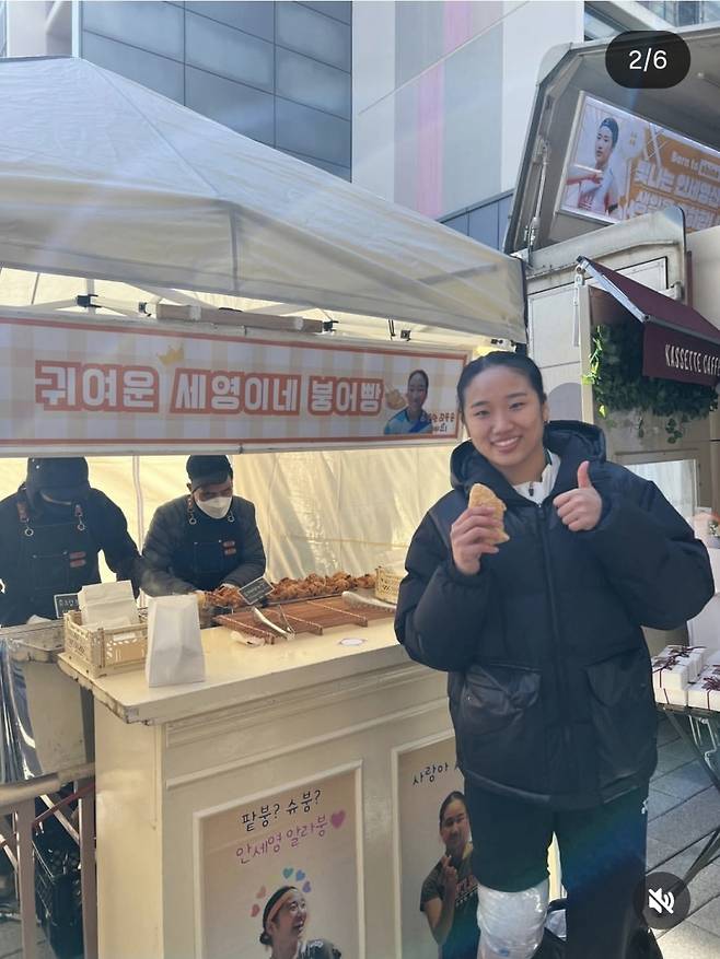 지난달 29일 팬들이 진천선수촌으로 보낸 붕어빵·커피차 앞에서 포즈를 취하고 있는 안세영. 사진=SNS