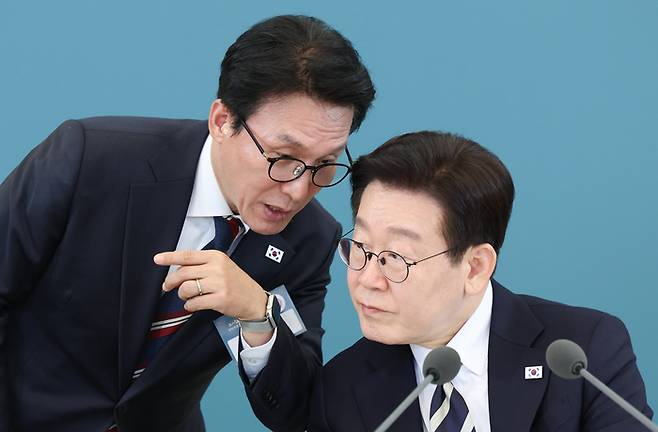 이재명 대통령이 지난 25일 청와대에서 열린 확대국가관광전략회의에서 김민석 국무총리와 대화하고 있다. [연합뉴스]