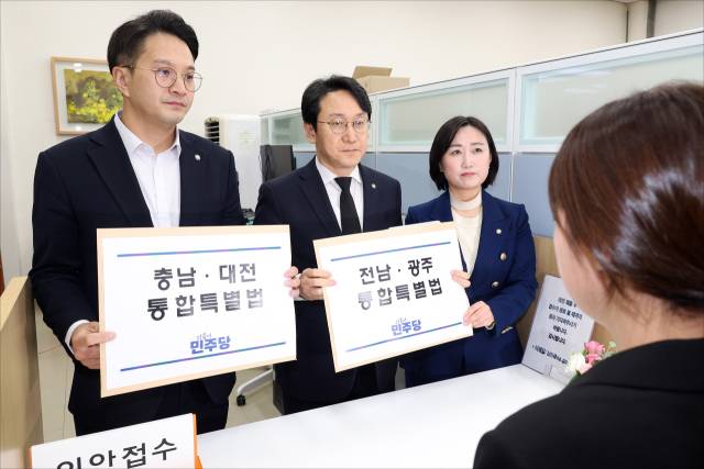 ▲더불어민주당 천준호 원내운영수석부대표(가운데), 전용기 원내소통수석부대표(왼쪽), 백승아 원내대변인이 30일 국회 의안과에 충남대전통합특별법안과 전남광주통합특별법안을 제출하고 있다. ⓒ연합뉴스