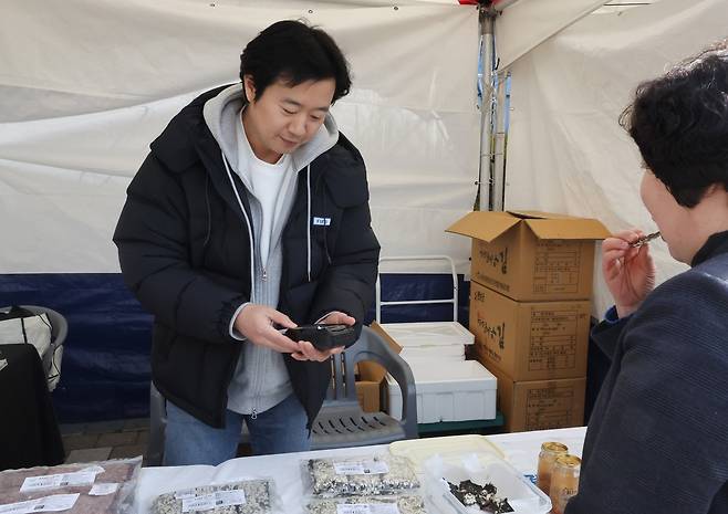 "지역 경제 활성화 기대" (장수=연합뉴스) 나보배 기자 = 전북 장수군민에게 '농어촌 기본소득'이 처음 지급된 26일 장수군청 앞에서 진행된 상생소비 한마당에서 농업법인을 운영 중인 박기덕 씨가 김부각을 판매하고 있다. 2026.2.26 warm@yna.co.kr