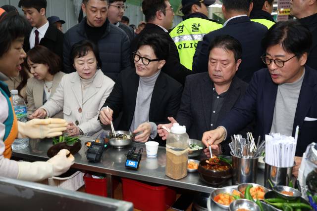 한동훈 국민의힘 전 대표가 27일 오후 대구 서문시장을 찾은 자리에서 일행들과 국수를 먹고 있다. 연합뉴스