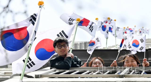 2·28민주운동 기념일 및 3·1절을 맞아 '태극기 달기 시범 운동'이 전개된 대구 달서구 월성코오롱하늘채 1단지 아파트에서 입주민들이 손에 태극기를 들고 태극기 달기 캠페인을 펼치고 있다. 대구일보DB