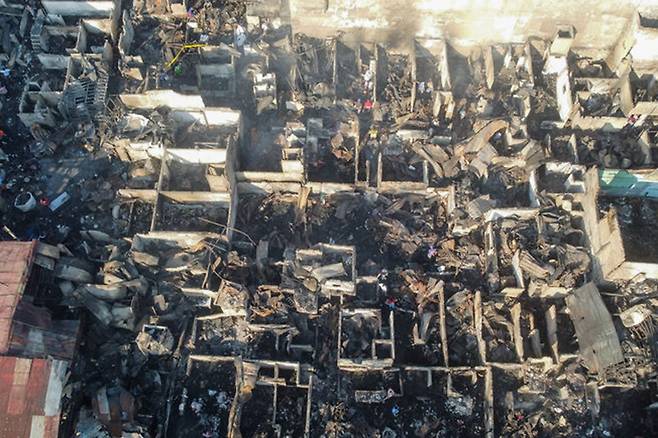 26일(현지 시간) 필리핀 마닐라 빈민가 화재 현장에 불에 탄 가옥들이 재로 남아 있다. 전날 오후 발생한 화재로 주택 수십 채가 소실되고 수백 가구가 대피했다. 뉴시스.