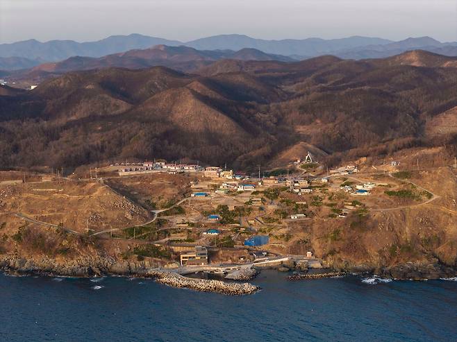 지난 23일 드론을 띄워 촬영한 경북 영덕군 영덕읍 석리마을 전경. 의성에서 시작된 산불이 옮겨오면서 역대급 대형 산불이 발생한 지 1년이 지났지만 뒷산과 마을 곳곳엔 산불 후유증이 여전히 남아 있다. 김정훈 기자