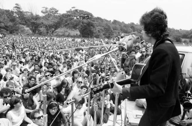 뉴포트 포크 페스티벌은 당시 미국 포크 음악의 정신적 중심지였다. 당시 포크 음악은 민권운동과 반전운동의 흐름 속에서 상업성과 거리를 둔 ‘진정성’의 문화로 받아들여졌고, 딜런은 그 중심에 서 있던 인물이었다. 그가 일렉 기타를 들고 등장한 순간, 논쟁은 곧바로 정체성과 신념의 문제로 확장됐다. 관중들이 느낀 배신감은 비단 소리의 변화에 대한 반감이 아닌, 자신들이 붙들고 있던 세계가 흔들렸다는 감각에서 비롯된 것이었다. [게티이미지/Photo by David Gahr]