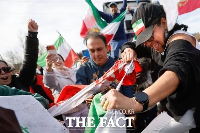 지난달 28일(현지시간) 미 워싱턴주 벨뷰에서 '보이스 오브 이란'의 창립자 겸 대표인 아레주 바간이 '보이스 오브 이란'이 주최한 차량 시위 중 이슬람 공화국 이란 국기를 찢고 있다. 이번 집회는 미국의 이란 공습과 관련해 열린 것으로, 참가자들은 이란 정부에 대한 비판과 변화를 요구하는 목소리를 냈다. /벨뷰=AP.뉴시스