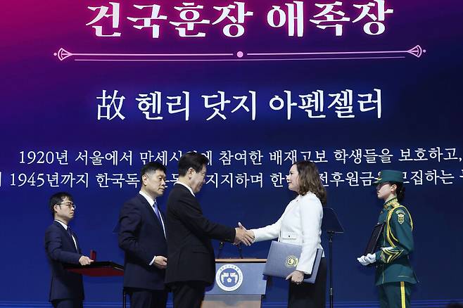 이재명 대통령이 1일 서울 강남구 코엑스에서 열린 제107주년 3·1절 기념식에서 고 헨리 닷지 아펜젤러의 유족인 증손녀 로라 아펜젤러 스가릴리아 씨에게 건국훈장 애족장을 수여하고 있다. 연합뉴스