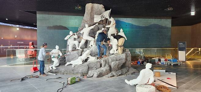 지난 27일 전남 나주시 공산면에 있는 남도의병역사박물관 1층 로비에서 1909년 전남 완도 소안도 의병 투쟁을 형상화한 ‘등대 암벽을 오르는 완도 소안도 의병들’ 조형물 설치 작업이 진행되고 있다.