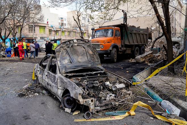 28일(현지시간) 이란 테헤란에서 이스라엘과 미국의 합동 공습으로 파괴된 차량의 잔해.[로이터]
