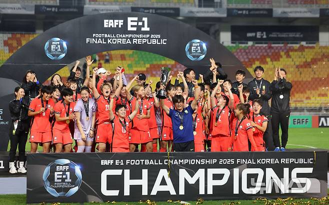 [수원=뉴시스] 김선웅 기자 = 16일 경기 수원시 수원월드컵경기장에서 열린 2025 동아시아축구연맹(EAFF) E-1 챔피언십(동아시안컵) 여자부 시상식에서 우승국 대한민국 대표팀 신상우 감독과 선수들이 트로피를 들고 기뻐하고 있다. 2025.07.16. mangusta@newsis.com