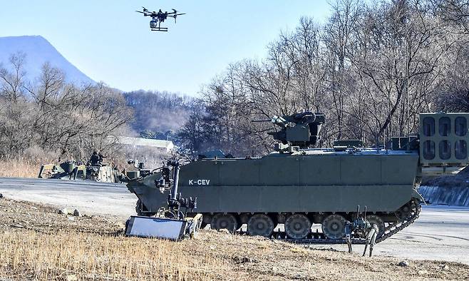 육군이 26일 양평종합훈련장에서 AI 기반 유·무인복합 한국형공병전투차량(K-CEV)의 첫 실전 훈련 현장을 공개했다. 사진은 장애물지대에 접근한 K-CEV가 정찰드론, 폭발물탐지제거로봇, 다족보행로봇과 함께 지뢰를 탐지하는 모습. 육군 제공