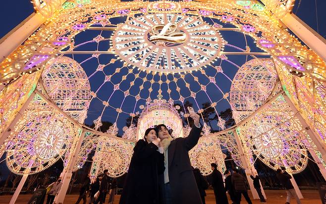 지난달 11일 오후 서울 송파구 롯데월드타워 월드파크에서 외국인 관광객들이 롯데물산 2026년 첫 시그니처 행사인  2026 롯데 루미나리에를 관람하고 있다./뉴스1