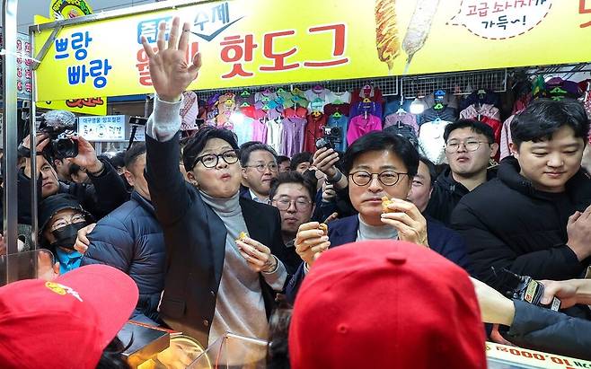 한동훈 국민의힘 전 대표가 지난달 27일 오후 대구 서문시장에 도착해 상인들이 건네는 음식을 먹고 있다. 연합뉴스