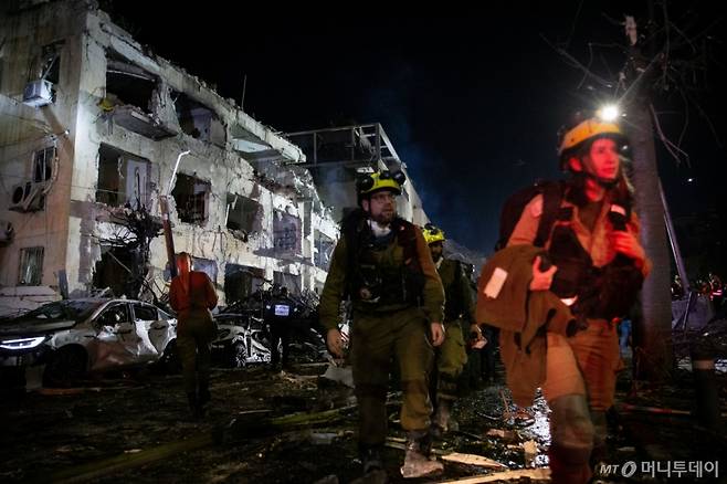 [텔아비브=신화/뉴시스] 1일(현지 시간) 이스라엘 텔아비브에서 구조대가 이란의 미사일 공격을 받은 현장을 수색하고 있다. 미국과 이스라엘이 지난달 28일 이란에 대해 '에픽 퓨리' 작전을 펼쳐 이란 최고지도자 아야톨라 알리 하메네이가 사망했다. 2026.03.01. /사진=민경찬