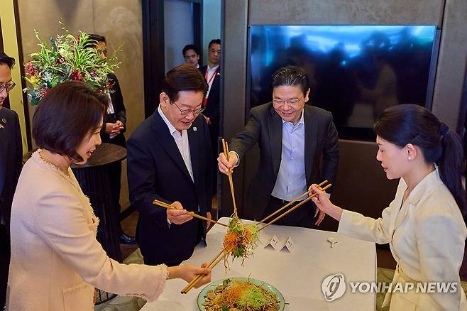 이재명 대통령, 싱가포르 총리와 친교오찬 (싱가포르=연합뉴스) 한상균 기자 = 이재명 대통령과 김혜경 여사가 2일 싱가포르 한 호텔에서 로런스 웡 총리 부부와 친교 오찬에 앞서 싱가포르 새해 음식인 생선회 샐러드를 섞으며 덕담을 나누고 있다. 2026.3.2 [공동취재 제공. 재판매 및 DB 금지] xyz@yna.co.kr