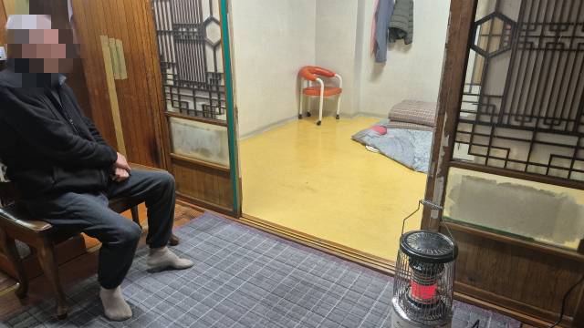 이승훈(70·가명) 씨가 자신의 집에서도 불편한 다리 때문에 벽에 기대 앉아 있다. 김지수 기자