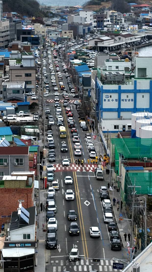 후포한 왕돌초광장 축제장 진입을 기다리는 관광객들의 차량이 후포항 시가지 도로를 꽉 메우고 있다.. 울진군 제공.
