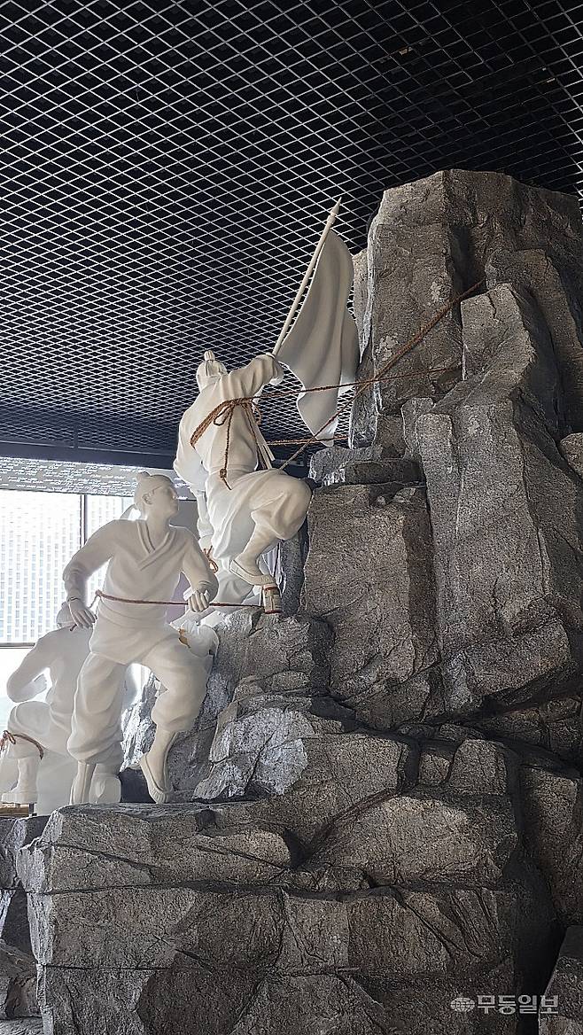 호남의병역사박물관 1층 입구에 자리한 ‘등대 암벽을 오르는 완도 소안도 의병들’ 작품.