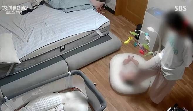 아이를 발로 밟는 ㄱ씨의 모습. 에스비에스(SBS) ‘그것이 알고싶다’ 방송 화면 갈무리