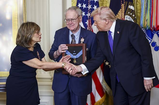도널드 트럼프 미국 대통령이 2일 미국 워싱턴 백악관에서 열린 명예훈장 수여식에서 유공자 가족에게 훈장을 전달하고 있다. UPI연합뉴스