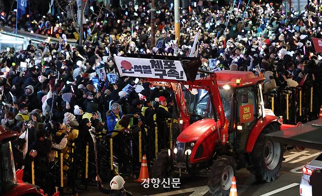 전국농민회총연맹 소속 농민들이 몰고 온 트랙터들이 2024년 12월 22일 서울 한남동 대통령 관저 인근에서 시위를 벌이며 행진하고 있다. 권도현 기자