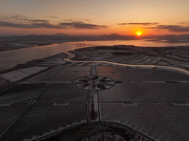 지난달 23일 전남 해남군에 위치한 솔라시도 태양광 발전소 넘어로 붉은 태양이 떠오르고 있다.