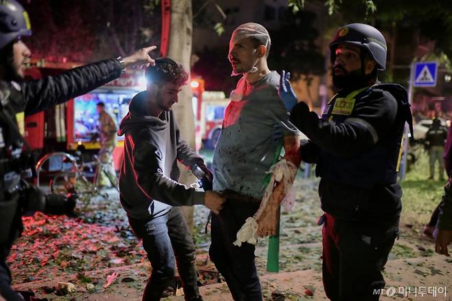 [텔아비브=AP/뉴시스] 지난달 28일(현지 시간) 이스라엘 텔아비브에서 구조대원들이 이란의 미사일 공격 피해 현장에서 부상 주민을 치료하고 있다. 2026.03.01. /사진=민경찬