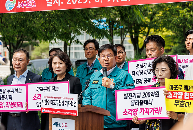 박강수(앞줄 왼쪽 세 번째) 서울 마포구청장이 지난해 6월 9일 마포자원회수시설 앞에서 ‘마포자원회수시설 공동이용협약 개정 철회 및 소각장 추가설치 반대’ 기자회견을 하고 있다. [마포구 제공]