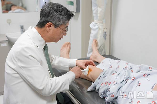 [서울=뉴시스] 고용곤 연세사랑병원 병원장이 환자의 무릎 관절강내 SVF를 주사하고 있다. (사진= 연세사랑병원 제공)