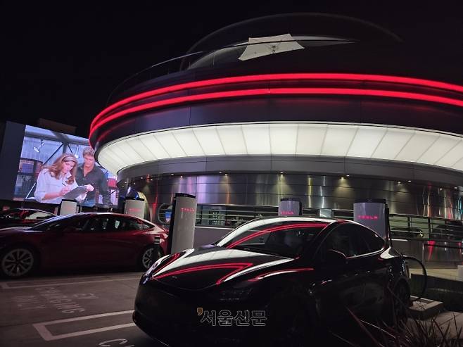 지난달 21일 미국 로스앤젤레스에 위치한 전기차 충전소 겸 휴게소 ‘테슬라 다이너’ 안의 전기차들이 충전기에 연결돼 있다.