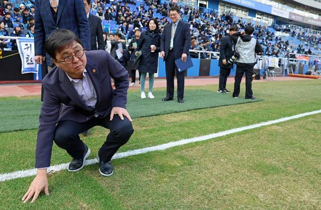 최휘영 장관이 인천축구전용경기장의 잔디 상태를 살펴보고 있다.  /사진=문체부