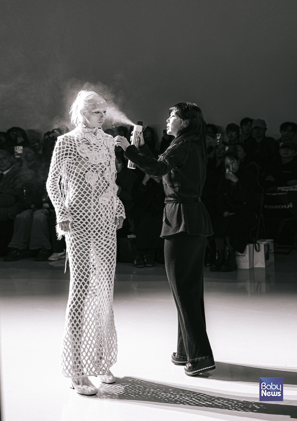 KIMOUI 26F/W 패션쇼 런웨이 위에서 로레알 프로페셔널 제품을 활용해 실시간으로 헤어 아트를 완성해가는 꼼나나 박제희 원장의 퍼포먼스 장면. ⓒ로레알코리아