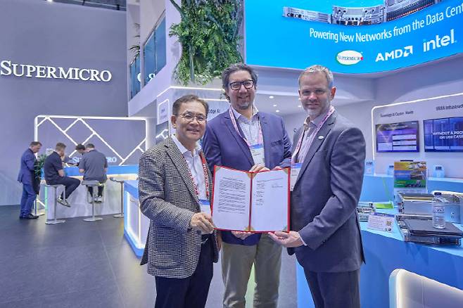 MWC26 슈퍼마이크로 전시관에서 기념 촬영 중인 (왼쪽부터) 하민용 SKT AI DC 사업 담당, 앤드류 브래드너 슈나이더 일렉트릭 수석 부사장, 클레이 시먼스 슈퍼마이크로 부사장의 모습. 사진=SK텔레콤