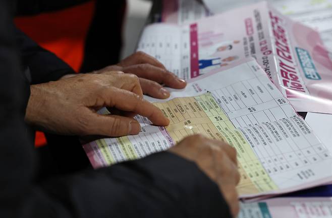 지난해 12월 10일 서울 마포구청에서 열린 노인일자리 박람회에서 어르신들이 참가업체 모집요강을 살펴보고 있다. 2025.12.10 뉴스1