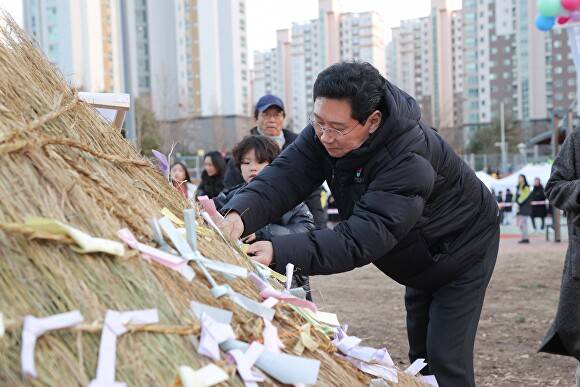 3일 수지구 신봉동에서 열린 '2026 신봉동 정월대보름 달맞이 축제'에서 이상일 시장이 소망을 담은 쪽지를 달집 태우기에 달고 있다. [사진=용인특례시]