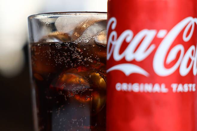 A glass of Coca-Cola with ice and Coca-Cola can (Getty Images)