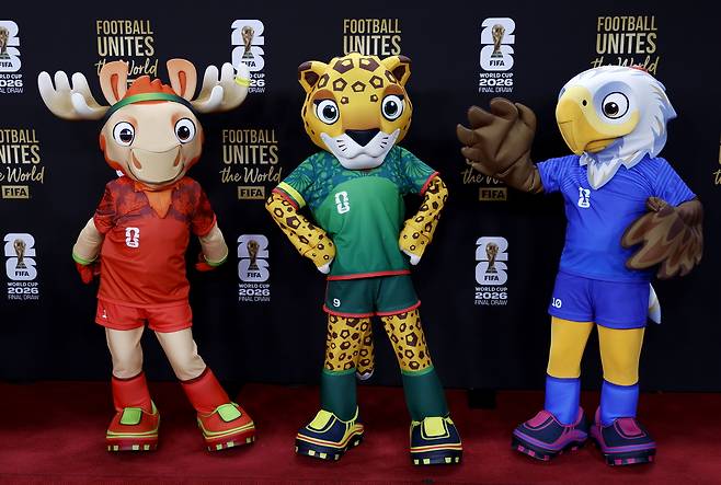 2025년 12월 5일(현지시간) 미국 워싱턴 D.C. 케네디센터에서 열린 FIFA World Cup 2026 본선 조 추첨 행사에 앞서 대회 공식 마스코트인 메이플 더 무스(캐나다), 자유 더 재규어(멕시코), 클러치 더 볼드 이글(미국)이 레드카펫을 걷고 있다. EPA
