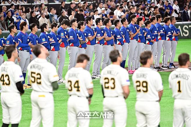 WBC 대만야구대표팀이 5일 일본 도쿄 도쿄돔에서 열린 호주와의 경기에 앞서 전광판에 새겨진 대만올림픽위원회기를 향해 예를 표하고 있다. 대만은 WBC에서 자국 국기(청천백일만지홍기)를 사용하지 못하고, ‘차이니스 타이베이’ 명칭과 대만올림픽위원회기(매화기)를 사용하게 되었다. 다만 관중들의 대만 국기 반입은 허용되었다. 도쿄(일본) | 박진업 기자 upandup@sportsseoul.com