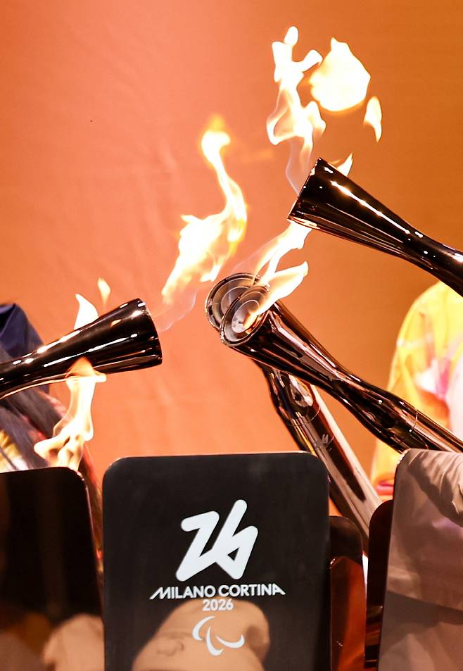 Torchbearers unify the flame during the Milan-Cortina 2026 Paralympic Winter Games Torch Relay and Flame Unifying Ceremony in Cortina D'Ampezzo, Italy, March 3, 2026.<저작권자(c) (Xinhua/연합뉴스, 무단 전재-재배포, AI 학습 및 활용 금지>