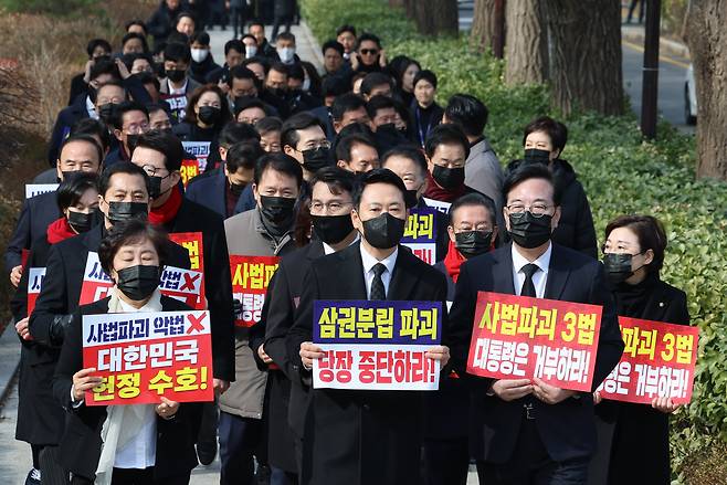 장동혁 대표와 송언석 원내대표를 비롯한 국민의힘 의원들이 5일 청와대 분수대 앞에서 의원총회를 마친 뒤 손팻말을 들고 청와대 방향으로 이동하고 있다. /연합뉴스