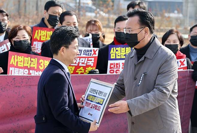 국민의힘 유상범 원내운영수석부대표가 5일 청와대 사랑채 앞에서 열린 의원총회에서 정을호 청와대 정무비서관에게 '3대 사법 파괴 악법' 철회 요구서를 전달하고 있다. 연합뉴스