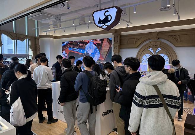 서울 홍대에 위치한 ‘호요버스 원신 카페 인 서울’ 내에 마련된 갤럭시 S26 시리즈 체험공간에서 관람객들이 갤럭시 S26 시리즈를 체험해보고 있다. [사진 = 삼성전자]