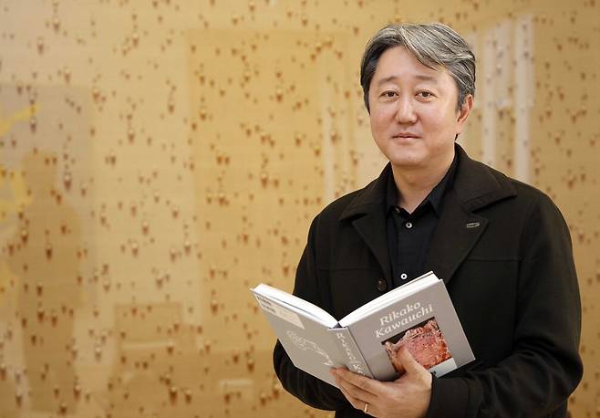 이정용 가나아트 대표가 다음달 아트오앤오에서 본격 소개할 일본 작가 가와우치 리카코 화집을 들고 포즈를 취하고 있다.   김호영 기자