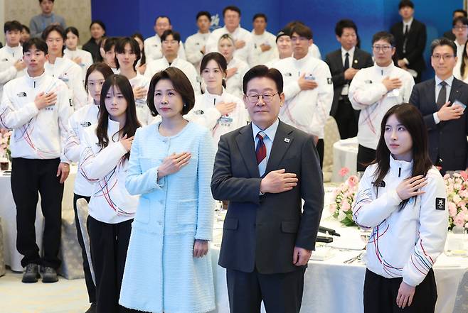 이재명 대통령과 김혜경 여사가 5일 청와대 영빈관에서 열린 2026 밀라노-코르티나담페초 동계올림픽 선수단 격려 오찬에서 국기에 경례하고 있다. 사진 | 연합뉴스