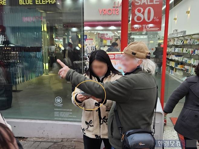 지난 3일 오후 5시경 서울 중구 명동거리에 한국과 대만 국기 배지를 모자에 단 60대 외국인 관광객이 화장품 로드샵 직원에게 종이지도로 길을 묻고 있다. 사진=박수빈 기자